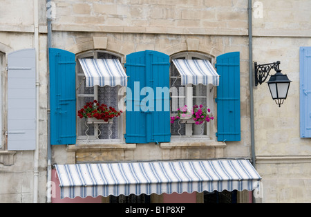 Bâtiment typique en Arles, Provence en France, avec des volets bleus et les jardinières de géraniums. Banque D'Images