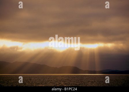 Les rayons du soleil / chevrons briser de gros nuages au-dessus de l'océan Pacifique, de la côte ouest, en Colombie-Britannique, British Columbia, Canada Banque D'Images