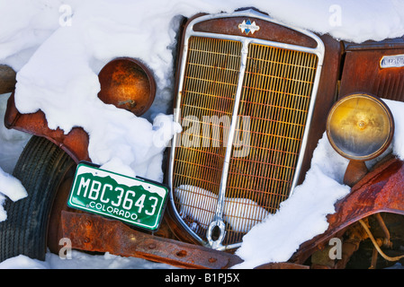 Une vieille voiture rouillée couverte de neige près de Steamboat Springs, Colorado, États-Unis. Banque D'Images