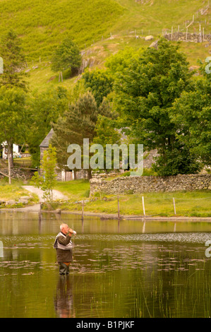 L'homme pêche de mouche sur Watendlath Tarn en été, Keswick Cumbria Lake District UK Banque D'Images