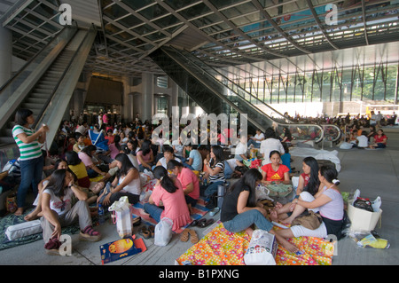 Comme employés de rassembler sous l'abri de l'immeuble HSBC sur leur journée de congé chaque dimanche à Hong Kong Banque D'Images