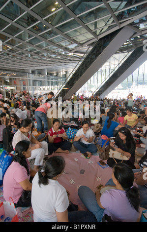 Comme employés de rassembler sous l'abri de l'immeuble HSBC sur leur journée de congé chaque dimanche à Hong Kong Banque D'Images