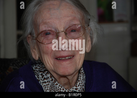 Une vieille femme qui sourit avec des lunettes Banque D'Images