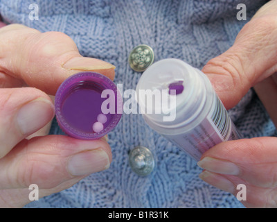 Femme âgée à l'aide d'un remède homéopathique arnica Banque D'Images