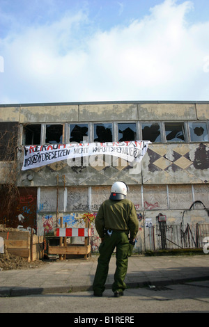 Agent de police surveillance d'une maison occupée par des squatters, Berlin, Germany, Europe Banque D'Images