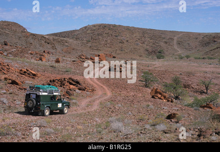 Land Rover dans le désert pierreux paysage près du Messum Crater, Namibie, Afrique Banque D'Images
