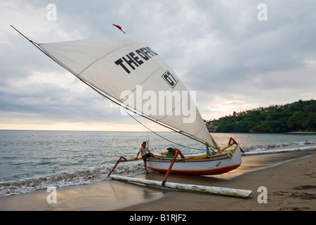 Outrigger bateau de pêche avec voile ouverte sur la plage de Senggigi Lombok, Île, Îles de la sonde Lesser, l'Indonésie, l'Asie Banque D'Images