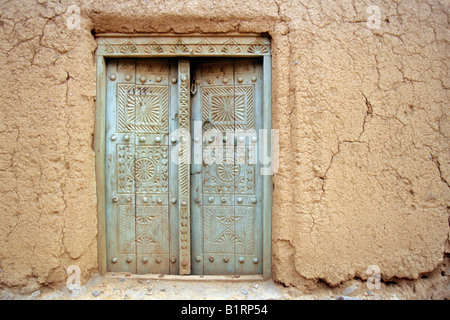 Vieille porte dans une maison de la terre, adobe, à Al Hamra, Oman, Péninsule Arabique, au Moyen-Orient Banque D'Images