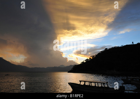 Le coucher du soleil, lumière arrière, dramatique nuages, bateau, lac Atitlan, Guatemala, Amérique Centrale Banque D'Images