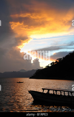 Le coucher du soleil, lumière arrière, dramatique nuages, bateau, lac Atitlan, Guatemala, Amérique Centrale Banque D'Images