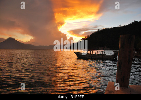 Le coucher du soleil, lumière arrière, dramatique nuages, bateau, lac Atitlan, Guatemala, Amérique Centrale Banque D'Images