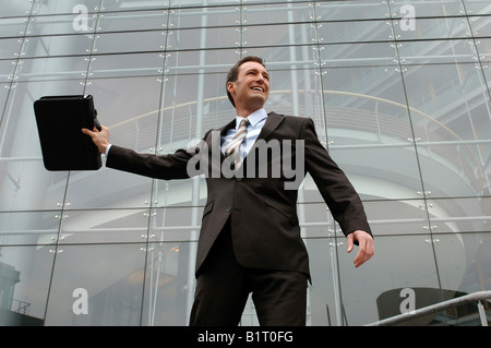 31-year-old woman wearing a suit, près d'une façade en verre Banque D'Images