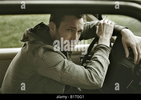 31-year-old man habillé comme James Dean, dans une voiture Banque D'Images