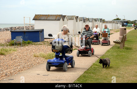 Les retraités sur leur mobilité buggies le long du front de mer à Goring près de Worthing UK Banque D'Images