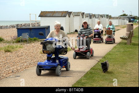 Les retraités sur leur mobilité buggies le long du front de mer à Goring près de Worthing Sussex UK Banque D'Images