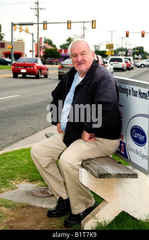 Un portrait homme assis sur un banc à un arrêt d'autobus à Oklahoma City, Oklahoma, USA. Banque D'Images