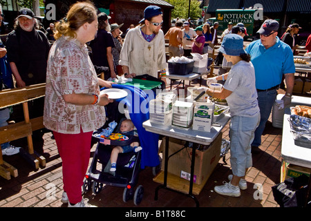 Une jeune famille avec un bébé inscrivez-vous d'autres personnes sans domicile pour une repas dominical dans O Bryant Square Portland Oregon Banque D'Images