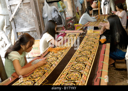 Tapisseries de couture des femmes dans un atelier de tapisserie marionnettes et autres souvenirs, AMARAPURA, MANDALAY MYANMAR BIRMANIE BIRMANIE Banque D'Images