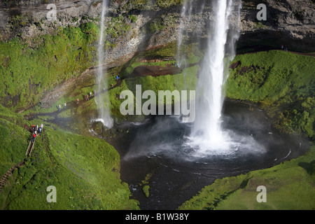 Les touristes visitant la cascade de Seljalandsfoss, Islande Banque D'Images