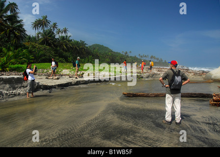 Groupe de touristes marchant sur la plage de Parc National Naturel de Tayrona, Colombie Banque D'Images