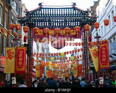 Angleterre Londres Chinatown foules passent par la porte d'ornement dans Gerrard Street pendant les célébrations du Nouvel An chinois Banque D'Images