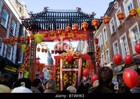 Angleterre Londres Chinatown foules passent par la porte d'ornement dans Gerrard Street pendant les célébrations du Nouvel An chinois Banque D'Images