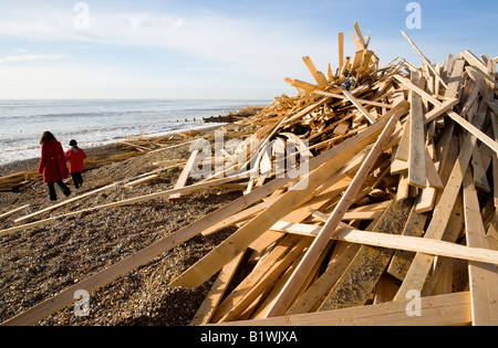 Worthing West Sussex en Angleterre Deux femmes marcher sur les débris de bois depuis la plage des naufragés Ice Princess comme des vagues sur le rivage de rupture Banque D'Images