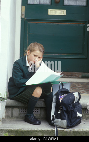 Enfant assis sur le démarchage en attente pour les parents de venir à la maison Banque D'Images