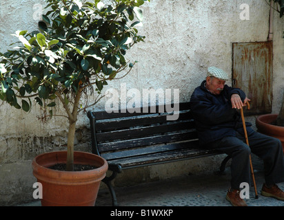 Vieil homme dormir sur banc, Cefalu, Sicile. Banque D'Images