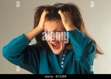 Woman holding agrippant ses cheveux et crier Banque D'Images