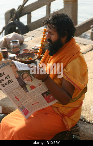 Sadhu lire le journal le matin après l'assassinat de Benazir Bhutto Banque D'Images