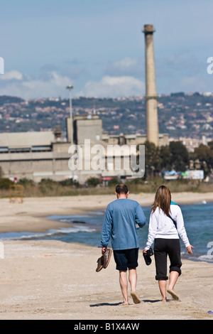 Couple marcher pieds nus le long de plage de Catane, Sicile, Italie Banque D'Images