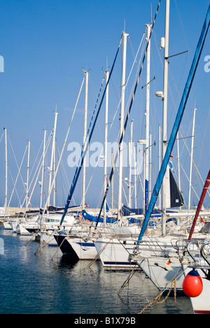 Vue verticale à travers une marina animée avec beaucoup de yachts coûteux amarré dans une rangée aux côtés de la jetée sur une journée ensoleillée Banque D'Images