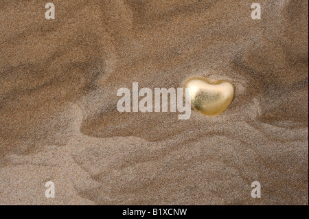 En forme de coeur en or sur la plage de galets de Findhorn, Moray, Ecosse Banque D'Images