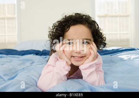 Girl lying on the bed and smiling Banque D'Images