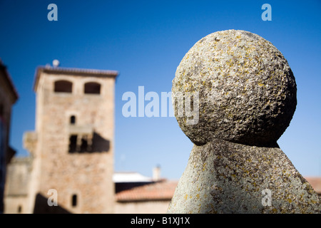 Balle en granit ornementales avec la tour de Golfines de Abajo palace, sur l'arrière-plan, la place San Jorge, Caceres, Espagne Banque D'Images