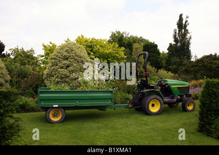 JOHN DEERE 4010 TRACTEUR ET REMORQUE TRAVAILLANT DANS UN JARDIN. Banque D'Images