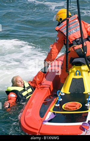 Batelier de sauvetage en mer en détresse sauve personne et obtient pour lui hors de l'eau avec facilité et rapidité Banque D'Images