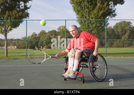 Hauts homme assis dans un fauteuil roulant et le tennis Banque D'Images