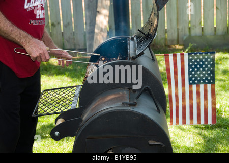 Un homme fume des côtes de porc pour sa famille célébration du Jour de l'indépendance. USA. Banque D'Images