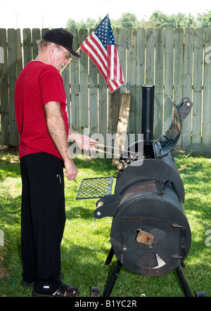 Un homme âgé fume des côtes de porc pour sa famille célébration du Jour de l'indépendance. USA. Banque D'Images