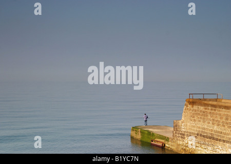 Pêche à l'homme à la fin d'une jetée Banque D'Images