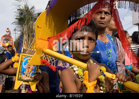 Jeune DÉVOT KAVADI PORTEUR AVEC LA PERFORATION DE LANGUE LORS DE L'Assemblée festival hindou de THAIPUSAM BATU CAVES KUALA LUMPUR, EN MALAISIE Banque D'Images