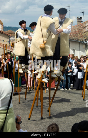 Les hommes de Les Landes en costumes traditionnels exécuter une danse sur échasses lors d'une fête du village à Auvillar, au sud-ouest de la France. Banque D'Images