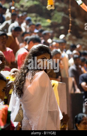 Femme DANS LA FOULE À REGARDER LES DÉVOTS HINDOUS ANNUEL FESTIVAL DE THAIPUSAM BATU CAVES KUALA LUMPUR, EN MALAISIE Banque D'Images