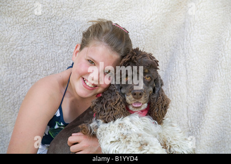 Une jeune fille de 13 ans avec son brun et blanc chien Cocker Américain Banque D'Images