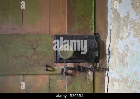Rusty serrure de porte sur une porte couverte de mousse. Banque D'Images