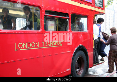 Les passagers par la plate-forme arrière du bus Routemaster Londres Banque D'Images