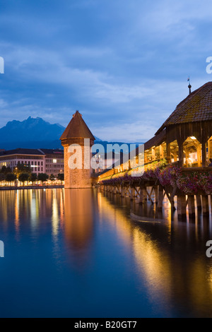 Reuss illuminés avec Kapellbruecke Pont de la chapelle et Wasserturm en soirée Lucerne Suisse Banque D'Images