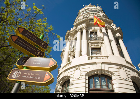 Espagne Madrid Metropolis building sur la rue Gran Via les flèches de direction et les panneaux pour des destinations touristiques populaires bilingues Banque D'Images